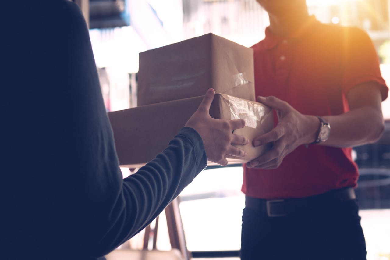 The Art of Drawing Readers In: Your attractive post title goes here Close-up of a delivery service worker handing over packages to a customer indoors.